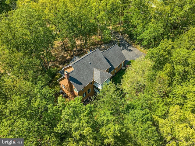 drone / aerial view with a wooded view