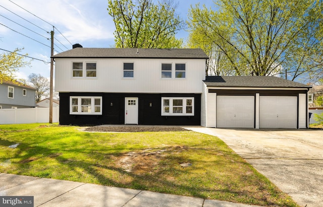 view of front facade with a front lawn, fence, driveway, and a garage