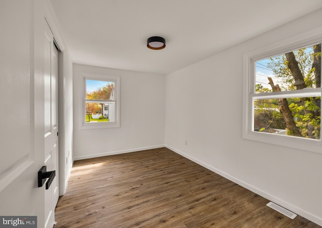 unfurnished bedroom featuring baseboards, wood finished floors, visible vents, and a closet