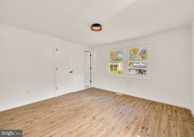 unfurnished room featuring light wood-style flooring and baseboards