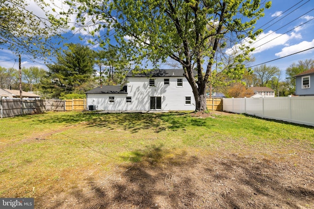 view of yard with a fenced backyard and central AC unit