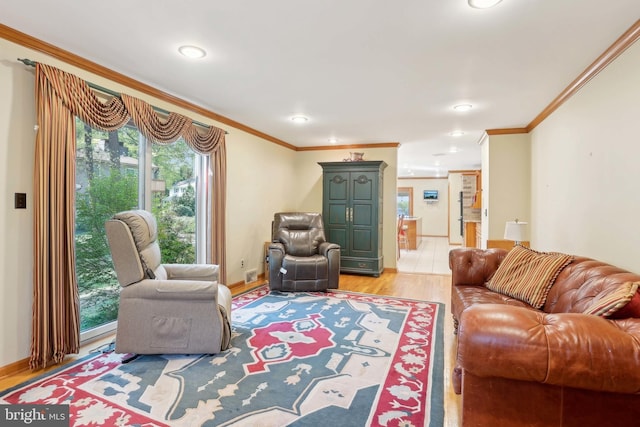 living area with healthy amount of natural light, ornamental molding, light wood-style floors, recessed lighting, and baseboards