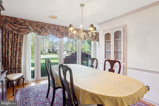 dining area featuring light wood finished floors and a chandelier