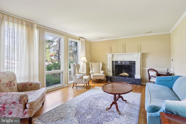 living room with crown molding, a high end fireplace, and wood finished floors