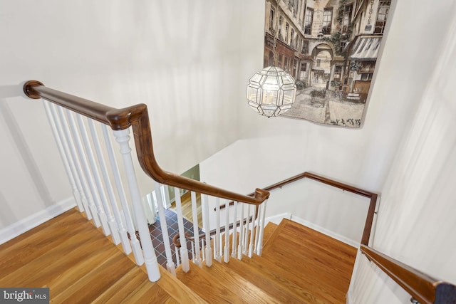 stairs with wood finished floors and baseboards