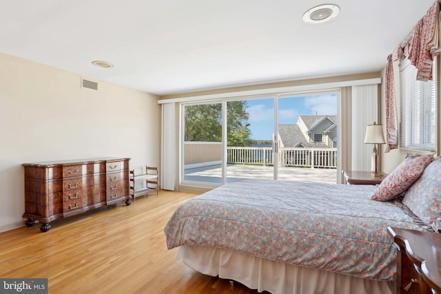 bedroom featuring access to outside and wood finished floors
