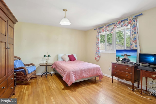 bedroom with light wood finished floors and baseboards