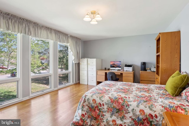 bedroom featuring light wood-style flooring and a chandelier
