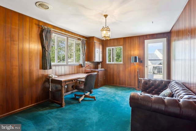 carpeted office space featuring wooden walls