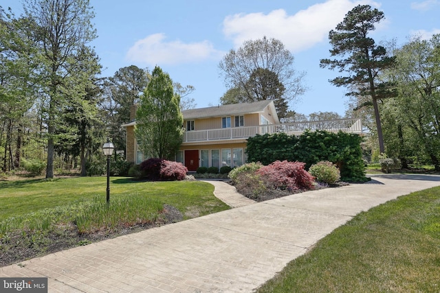 view of property featuring a front lawn and a chimney