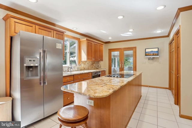 kitchen featuring stainless steel fridge, black electric cooktop, healthy amount of natural light, a sink, and ornamental molding