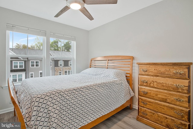 bedroom with a ceiling fan, baseboards, and wood finished floors