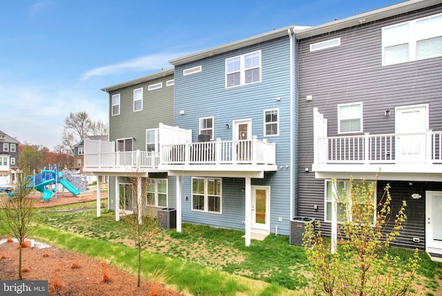 back of house featuring central AC and a playground