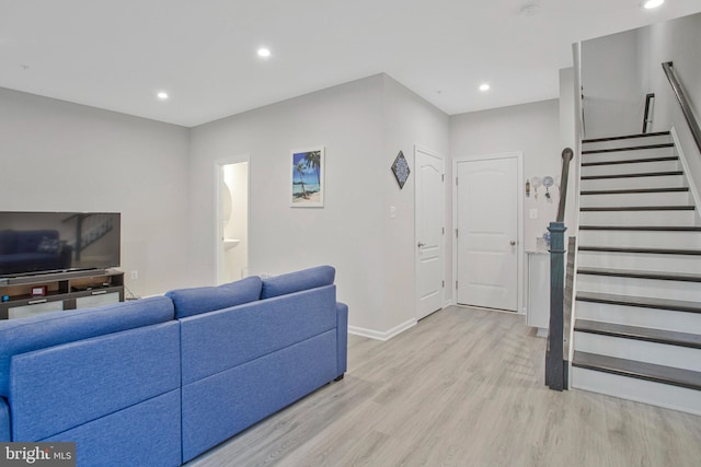 living room featuring recessed lighting, light wood-style flooring, baseboards, and stairway