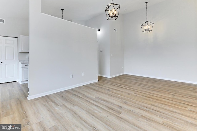 9552 Cannoneer Ct Unit 403, Manassas, VA 20110 - unfurnished dining area with a chandelier, a high ceiling, light wood-type flooring, and baseboards