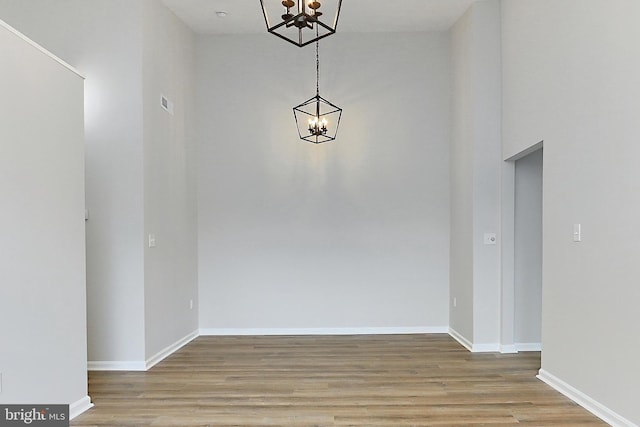 9552 Cannoneer Ct Unit 403, Manassas, VA 20110 - unfurnished dining area with a chandelier, wood finished floors, baseboards, and a towering ceiling