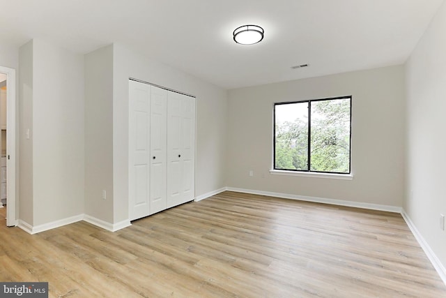 9552 Cannoneer Ct Unit 403, Manassas, VA 20110 - unfurnished bedroom featuring light wood-type flooring, a closet, and baseboards