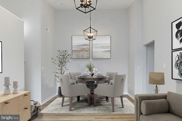 9552 Cannoneer Ct Unit 403, Manassas, VA 20110 - dining space featuring a chandelier, wood finished floors, a high ceiling, and baseboards