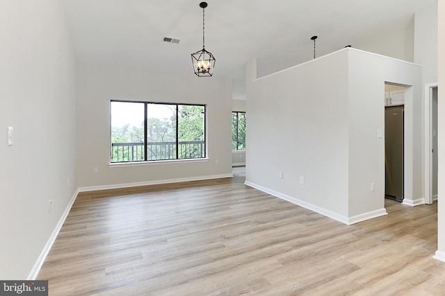 9552 Cannoneer Ct Unit 403, Manassas, VA 20110 - unfurnished living room with light wood-style floors, a chandelier, baseboards, and a towering ceiling