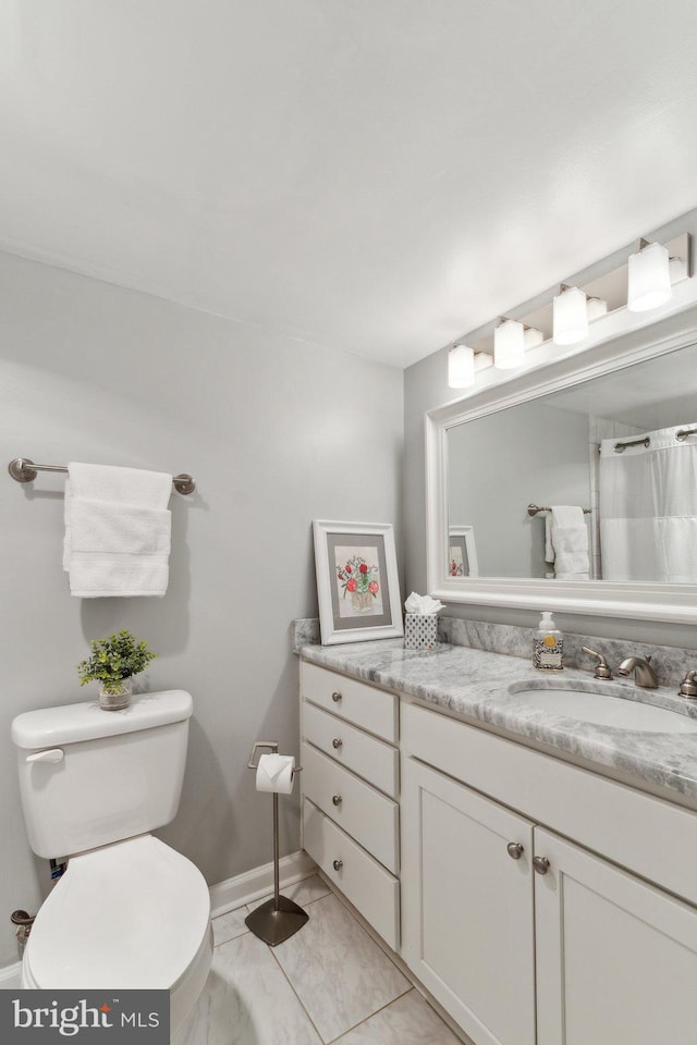 full bathroom featuring baseboards, marble finish floor, toilet, and vanity