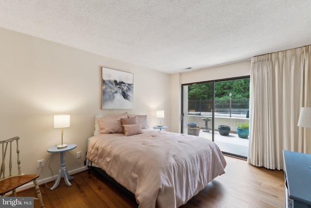 bedroom with access to outside, a textured ceiling, baseboards, wood finished floors, and visible vents