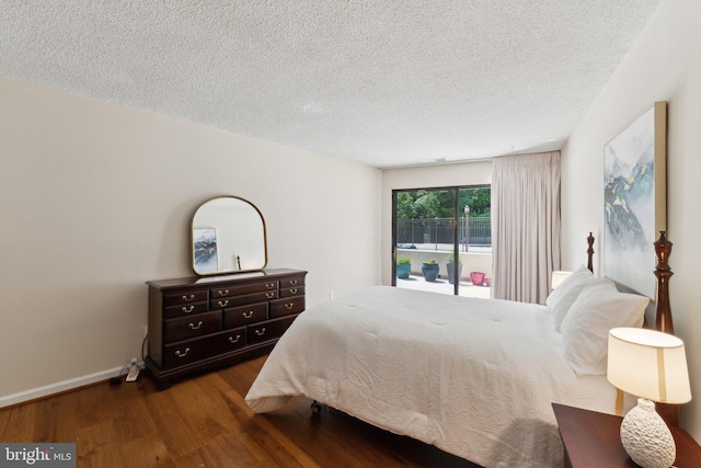 bedroom with baseboards, a textured ceiling, and wood finished floors