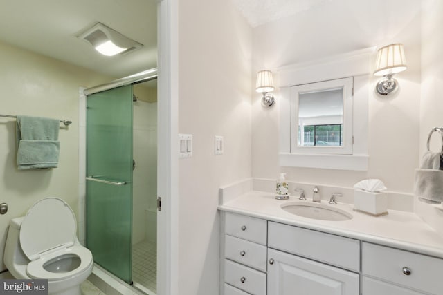 full bath with vanity, a shower stall, and toilet