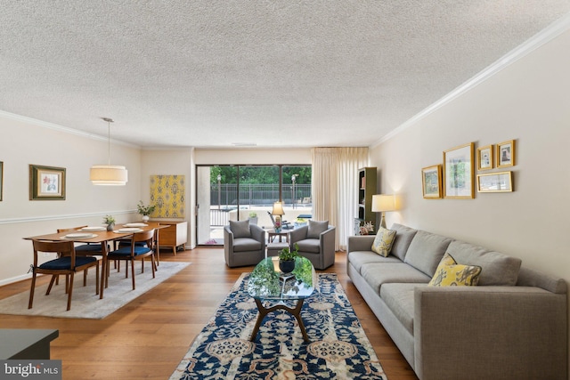living area with crown molding, a textured ceiling, and wood finished floors