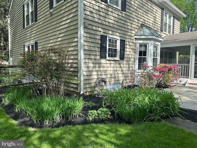 view of property exterior with a sunroom