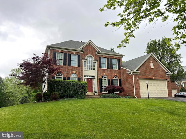 view of front of home featuring an attached garage, brick siding, driveway, and a front yard
