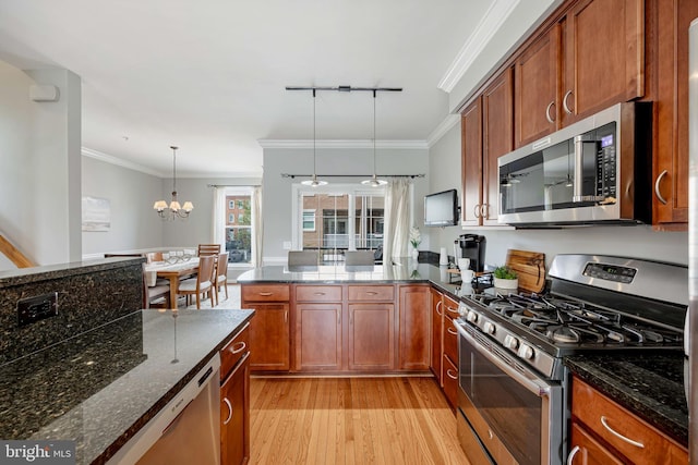 2331 Cambridge Walk, Baltimore, MD 21224 - kitchen featuring light wood finished floors, ornamental molding, dark stone counters, brown cabinetry, and appliances with stainless steel finishes