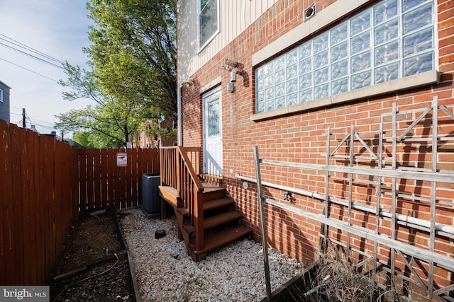 2331 Cambridge Walk, Baltimore, MD 21224 - view of home's exterior featuring central AC, brick siding, and fence
