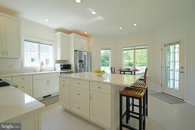 kitchen featuring stainless steel appliances, a sink, healthy amount of natural light, recessed lighting, and light countertops