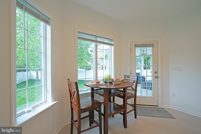 dining room featuring plenty of natural light and baseboards