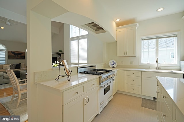 kitchen with gas stove, a sink, plenty of natural light, and recessed lighting