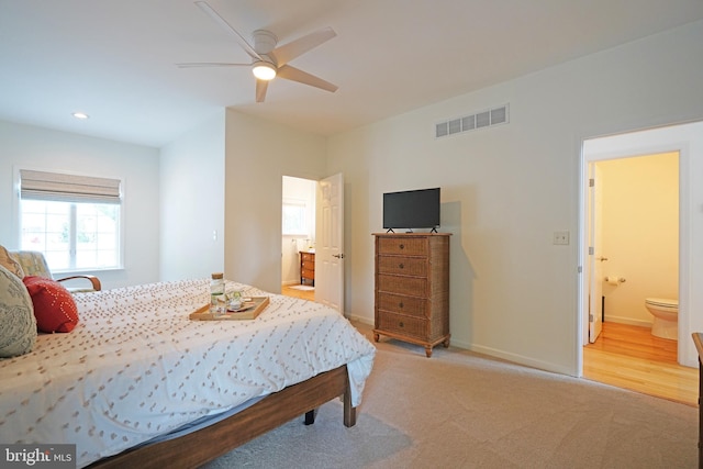 bedroom with ensuite bath, baseboards, light colored carpet, recessed lighting, and ceiling fan