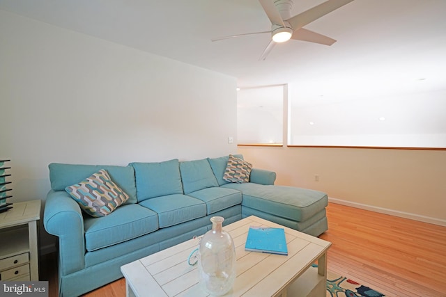 living room featuring light wood finished floors, a ceiling fan, and baseboards