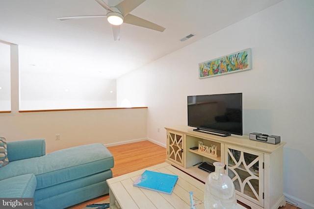 living area featuring ceiling fan, wood finished floors, and baseboards