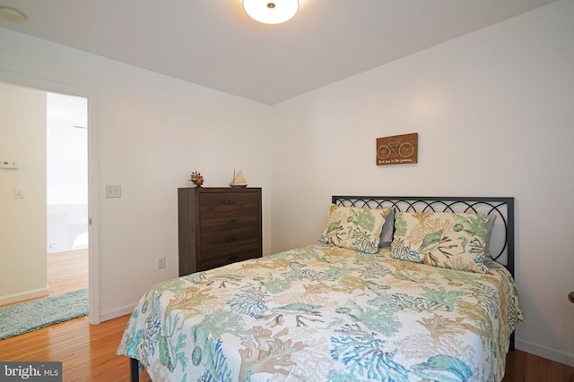 bedroom featuring wood finished floors and baseboards