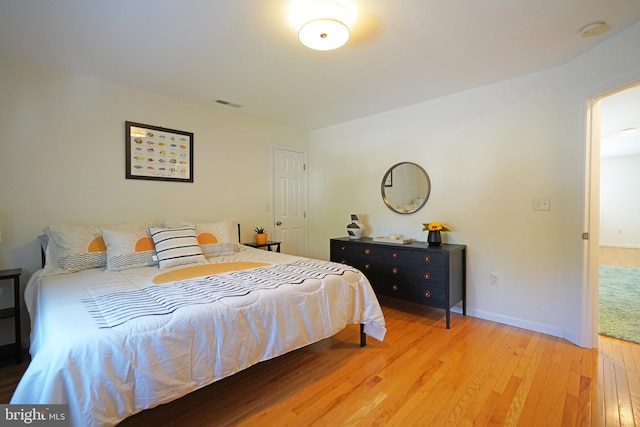 bedroom with light wood-type flooring and baseboards