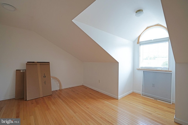 additional living space with lofted ceiling, wood-type flooring, and baseboards