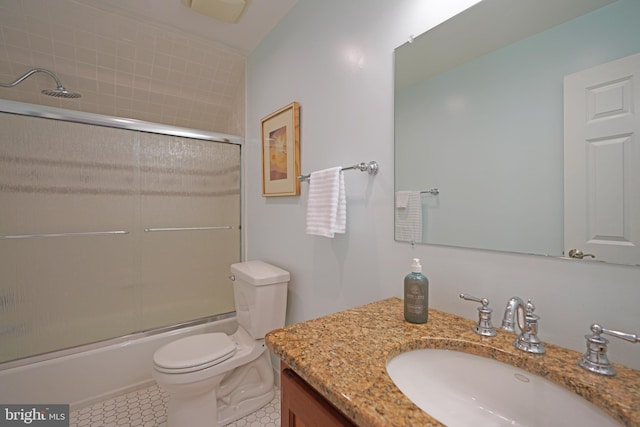 bathroom featuring toilet, vanity, enclosed tub / shower combo, and tile patterned floors