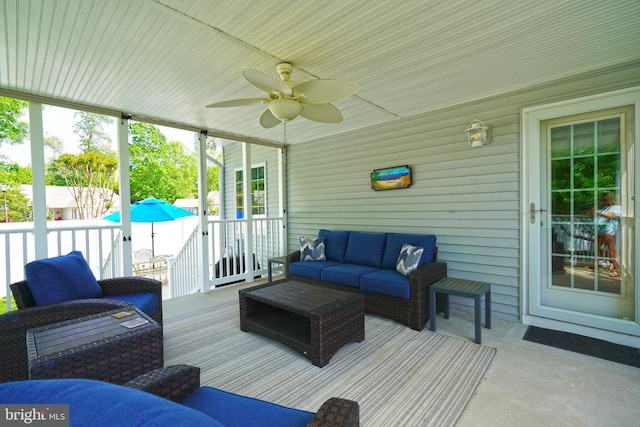 wooden terrace with an outdoor hangout area and a ceiling fan