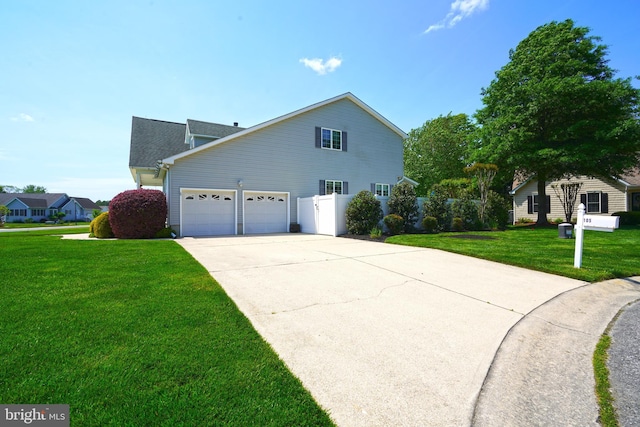 view of side of property with a lawn, driveway, and an attached garage
