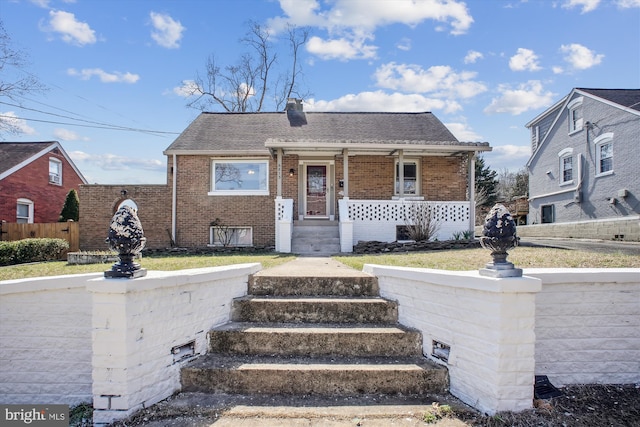 6813 Chestnut Ave, Falls Church, VA 22042 - bungalow-style house featuring roof with shingles, a chimney, covered porch, fence, and brick siding