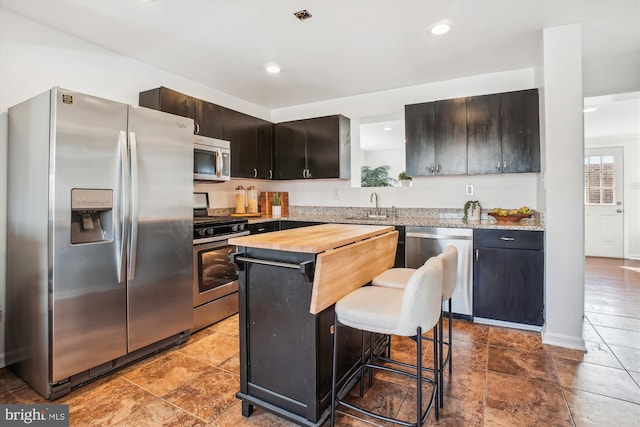 6813 Chestnut Ave, Falls Church, VA 22042 - kitchen with a center island, butcher block countertops, a sink, a breakfast bar area, and stainless steel appliances
