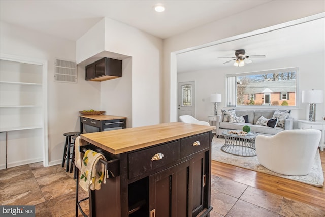 6813 Chestnut Ave, Falls Church, VA 22042 - kitchen featuring butcher block counters, dark brown cabinetry, ceiling fan, and light tile patterned floors