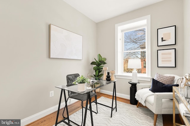 home office with baseboards and wood finished floors