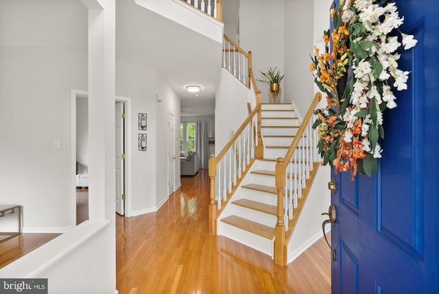 entrance foyer featuring stairway, baseboards, and wood finished floors