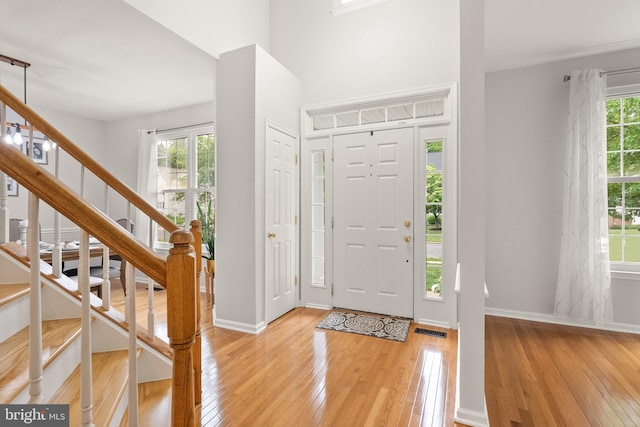entryway featuring baseboards, stairs, visible vents, and hardwood / wood-style flooring